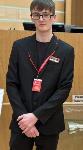 Jamie with visitors badge at The Scottish Parliament