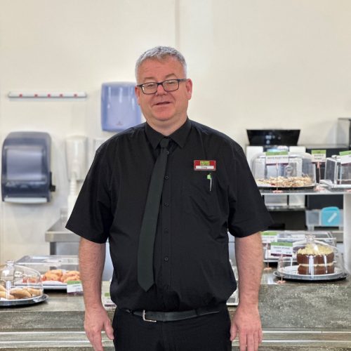 Man standing in front of cafe counter