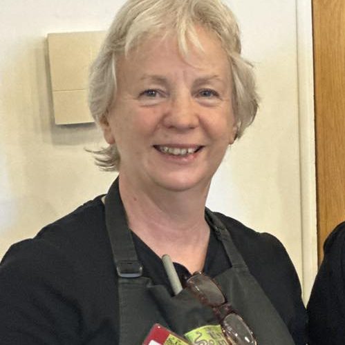 Woman in The Usual Place Uniform smiling at camera